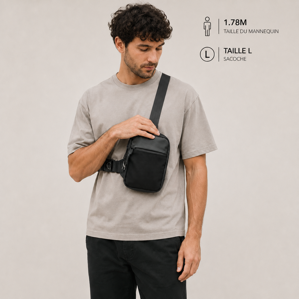 Homme portant la sacoche crossbody antivol VALUNE noire en bandoulière sur un t-shirt beige