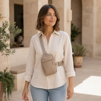 Femme en chemise claire portant la sacoche bandoulière VALUNE beige en extérieur